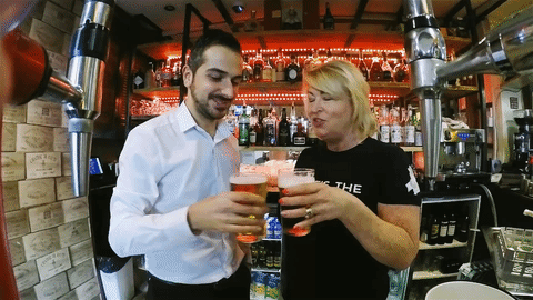 animated gif of a two people doing a cheers with beer