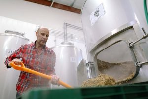 man emptying the spent grain from the mash tun