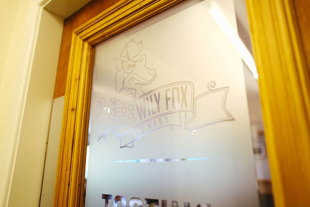 frosted logo of a brewery on a glass door