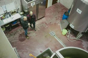 men standing in a working brewery