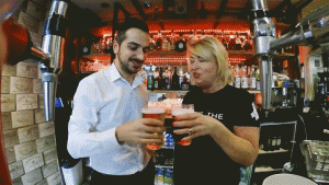 animated gif of a two people doing a cheers with beer