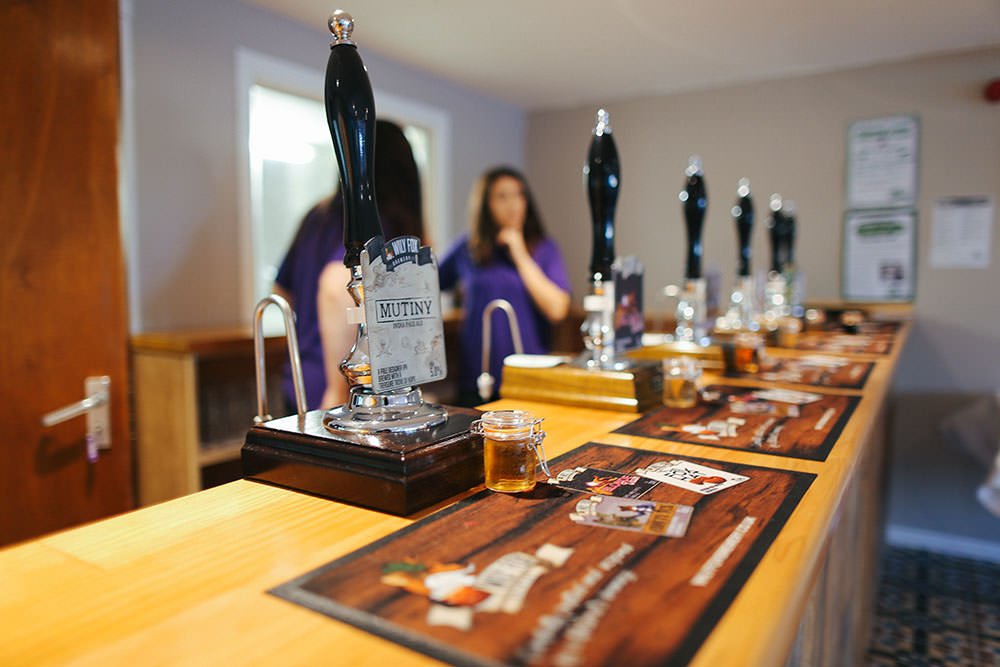 photo of a line of cask beer handpumps along a bar