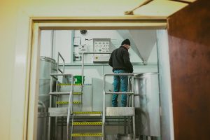 brewer oversees brewing of beer collaboration in brewery